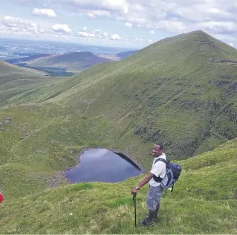  ?? (Pic: Marian Roche) ?? A hiker stands over Lough Diheen, where the serpent still sleeps today.