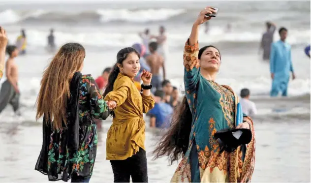  ?? Agence France-presse ?? ↑
A woman takes a selfie at the Clifton beach on the last day of Eid holidays in Karachi on Thursday.