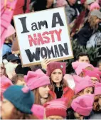  ??  ?? NASTY IN PINK: A woman holds a sign amid a sea of pink caps before a women’s march in Seattle.