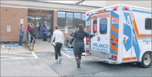  ?? GLEN WHIFFEN/THE TELEGRAM ?? A student, with a triage tag attached to his arm, leaves an ambulance and heads back into Prince of Wales Collegiate Wednesday. Students gathered to watch a fight at recess were hit with bear spray, resulting in an emergency response from paramedics and police, and the school going into secure mode.