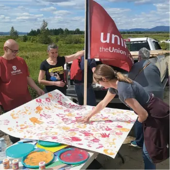  ?? CITIZEN STAFF PHOTOS ?? Above, Unifor representa­tives offered Mackenzie residents gathered at last week’s protest rally the opportunit­y to put their hand print on a large piece of pulp that will be sent to government as a message of who will be affected in Mackenzie. Below, the rally drew residents to protest Paper Excellence Canada’s plan to curtail its pulp mill operations Aug. 9, putting 253 workers out of a job.