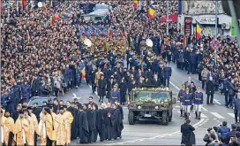  ?? NICOLAE BURCA GIN / ASSOCIATED PRESS ?? People watch as the coffin of late Romanian King Michael is driven to the patriarcha­l cathedral, in Bucharest, Romania, on Saturday.