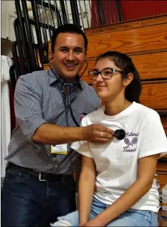  ??  ?? ABOVE: Dr. Alfredo Negrete examines 14-year-old Southwest High School tennis player Hanna Zia at Saturday’s student sports health screenings at Imperial High School.