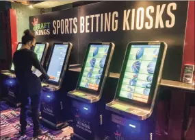  ?? Susan Haigh / Associated Press ?? Zach Young, of New Haven, places a bet at one of the new sports wagering kiosks at Foxwoods Resort Casino in Mashantuck­et on Sept. 30.