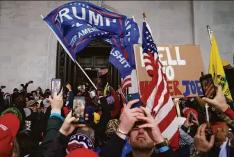  ?? John Minchillo / Associated Press 2021 ?? Rioters loyal to former President Donald Trump swarm the Capitol in Washington on Jan. 6, 2021, in a bid to disrupt a joint session of Congress as it certified the Electoral College vote.