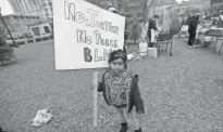  ??  ?? Faith Hunt, 4, who was with her mother, Erica Hunt, not pictured, of Milwaukee holds a sign she made during the Peoples Revolution event at Cathedral Square Park in Milwaukee on Saturday.