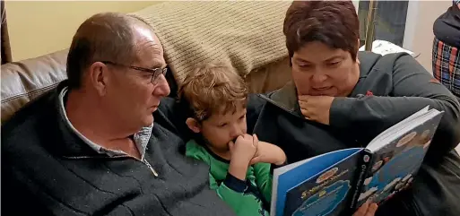  ??  ?? Chester and Ella Borrows read to grandson Jimmy during a visit to Canada.