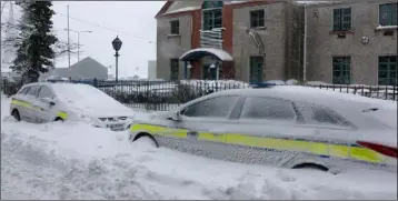  ??  ?? Garda cars snowed in outside Enniscorth­y Garda Station.