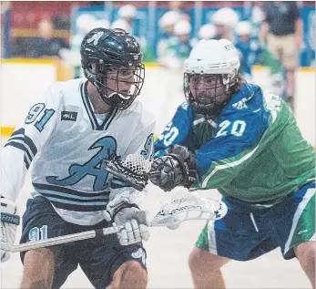  ?? JULIE JOCSAK THE ST. CATHARINES STANDARD ?? Brett Erskine of the St. Catharines Athletics tries to keep the ball away from Mitch Ogilvie of the Peterborou­gh Lakers in junior A lacrosse action at Jack Gatecliff Arena in St. Catharines on Wednesday.