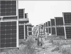 ?? LIU LEI / XINHUA ?? Employees check a solar power plant in Kubuqi desert, the Inner Mongolia autonomous region, in April.