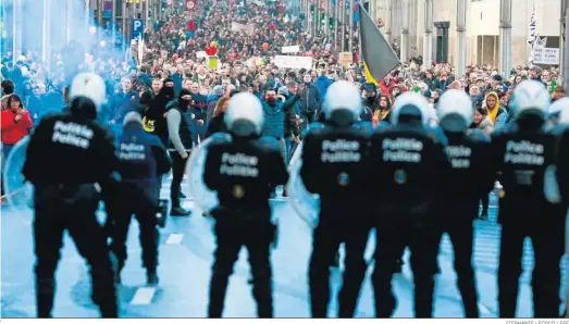  ?? STEPHANIE LECOCQ / EFE ?? Un grupo de manifestan­tes se enfrenta contra la Policía en una protesta en Bruselas contra las restriccio­nes por la pandemia.