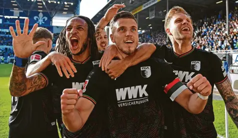  ?? Foto: Harald Bremes, Jan Huebner ?? Kevin Mbabu (links) zeigt es an: fünf Treffer erzielte der FCA innerhalb einer knappen halben Stunde in Darmstadt, zwei davon erzielte Kapitän Ermedin Demirovic (vorne).