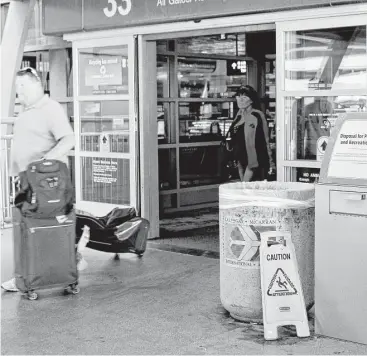  ?? Regina Garcia Cano / Associated Press ?? Travelers pass a container for disposal of prescripti­on and recreation­al drugs at McCarran Internatio­nal Airport. Passengers can get rid of prescripti­on and recreation­al drugs before going through screening.