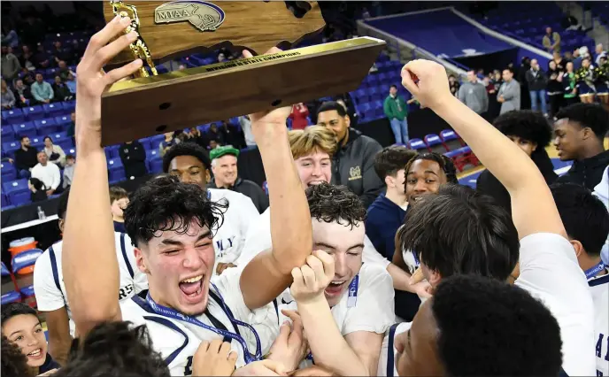  ?? PHOTO BY MARK STOCKWELL — BOSTON HERALD ?? Malden Catholic’s Nicholas Martinez holds up the championsh­ip trophy as he celebrates with his team after defeating Mansfield, 72-54, in the MIAA Div. 2 boys basketball championsh­ip at the Tsongas Center in Lowell.