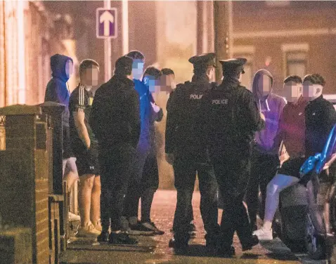  ?? KEVIN SCOTT ?? Police talking to young people on the streets of Belfast’s Holyland area late at night