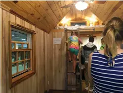  ?? Tribune News Service ?? Families explore a tiny home with a loft, rain showerhead and stainless steel appliances during the Great America Tiny House Show at the North Carolina State Fairground­s.