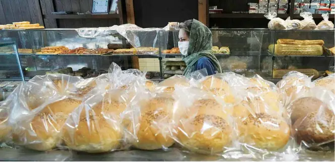  ?? ?? A customer looks at display cases in a bakery in Tehran, Iran, Wednesday, May 11, 2022. Iran abruptly raised prices as much as 300% for a variety of staples such as cooking oil, chicken, eggs and milk on Thursday. (AP)