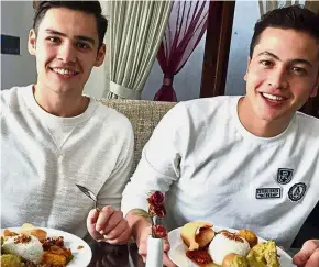  ??  ?? A taste of Malaysia: Daler (right) and his brother Sherzod tucking into some local delicacies.