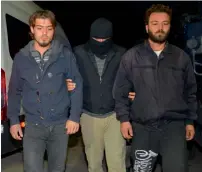  ?? — AFP ?? A masked Turkish special force police officer detains two men during a house raid to arrest suspected members of the Daesh group in Adana on Friday.