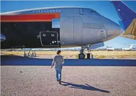  ?? New York Times ?? Brandi Lange, operations manager for Logistic Air, walks to a cargo Boeing 747 her company helps maintain at Pinal Airpark in Marana, Arizona.