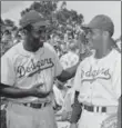  ??  ?? Brooklyn Dodger catcher Roy Campanella, seen here with teammate Jackie Robinson, won his third National League MVP title (a car crash left him paralyzed in 1958), 62 years ago today.