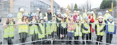  ??  ?? Big moment Pupils and staff watched as a time capsule containing school uniform items and photos was buried in the grounds of the under-constructi­on St Edward’s and Tollbrae joint campus