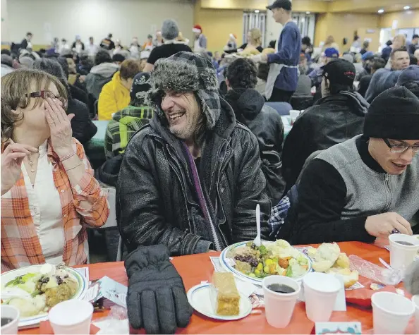  ?? LARRY WONG ?? Kenneth Poirier, middle, enjoyed a filling meal at the first of four annual Christmas banquet dinners being held this year at the Hope Mission in Edmonton on Monday. For the Christmas dinners, the mission is playing host to two seatings per night,...