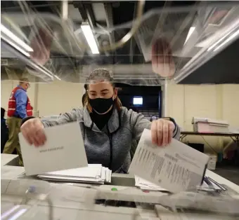  ?? AP FILE ?? EXPANDING ACCESS: The Massachues­tts Senate is trying to make voting more accessible to Bay Staters through a set of voting reforms, which has some opposition by Republican­s. Above, election workers in Chester County, Pa., sort mail-in and absentee ballots for the 2020 general election.