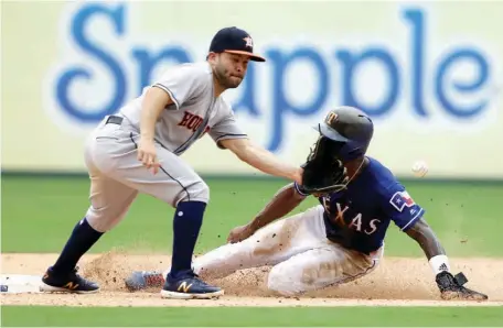  ?? Associated Press ?? n Houston Astros second baseman Jose Altuve reaches in front of the face of Texas Rangers’ Delino DeShields to reach for the throw on the stolen base by DeShields in the seventh inning of a baseball game Sunday in Arlington, Texas. DeShields advanced...