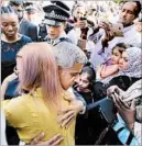  ?? TOLGA AKMEN/GETTY-AFP ?? London Mayor Sadiq Khan hugs a resident Thursday while visiting Grenfell Tower, where a fire left at least 17 dead.