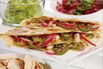  ?? MICHAEL TERCHA PHOTOS/CHICAGO TRIBUNE ?? Chicken quesadilla­s are brightened with quick-pickled red onion and jalapenos and enriched with cheese, all folded into a tortilla.