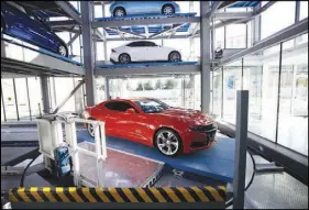  ??  ?? A 2019 Chevrolet Camaro SS rotates after being lowered down Carvana’s Las Vegas vending machine.