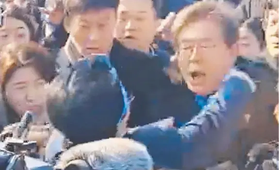  ?? Pictures: AFP ?? The moment Lee Jae-myung is stabbed in the neck by an attacker after (below) giving a speech at the port of Busan. People rushed to help (below).