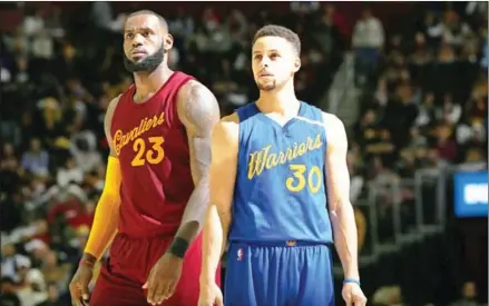  ?? DAVID SHERMAN/NBAE/GETTY IMAGES/AFP ?? LeBron James of the Cleveland Cavaliers (left) and Stephen Curry of the Golden State Warriors react to a play during their game on December 25 at Quicken Loans Arena in Cleveland, Ohio.
