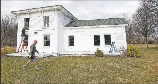  ??  ?? Workers for Especially Windows and Remodeling in Highland install new windows at the Banks-Dolbeer-Bradley-Foster Farmhouse in Walled Lake, Mich. (Detroit Free Press/Eric Seals)