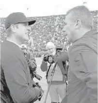  ?? TONY DING/AP ?? Ohio State’s Urban Meyer, right, defeated Jim Harbaugh and Michigan all four times the coaches met head to head in one of college football’s biggest rivalries. Meyer stepped down in January.