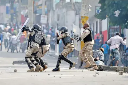  ?? Tribune News Service ?? Haitian police clash with demonstrat­ors during a march through the streets of Port-au-prince, on November 23, 2018, to demand the resignatio­n of the President of Haiti, Jovenel Moise.