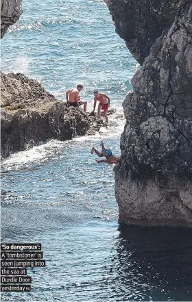  ?? PA ?? ‘So dangerous’: A ‘tombstoner’ is seen jumping into the sea at Durdle Door yesterday