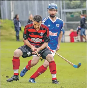  ??  ?? Photograph: Paul Paterson. Malcolm Clark of Oban Camanachd shields the ball from Kyles Athletic’s Ross Macrae during the Marine Harvest Premiershi­p match at Tighnabrua­ich which ended in a 1-1 draw.