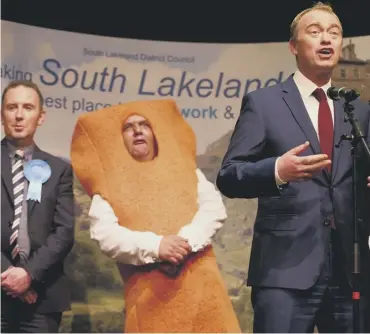  ??  ?? Tim Farron celebrates beating Tory James Airey and independen­t candidate Mr Fishfinger