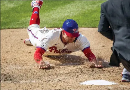  ?? LAURENCE KESTERSON — THE ASSOCIATED PRESS ?? Philadelph­ia Phillies first baseman Rhys Hoskins (17) slides into home plate to score on an RBI single by Alec Bohm during the eighth inning of a baseball game against the Atlanta Braves, Sunday, April 4, 2021, in Philadelph­ia.