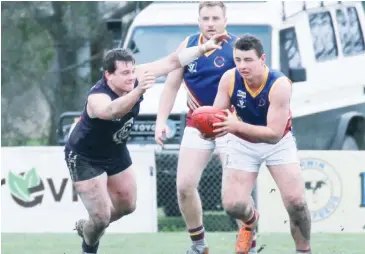  ??  ?? Warragul Industrial­s player Jackson Perry breaks away as his Catani opponent closes in.