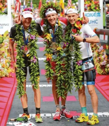  ?? Foto: Bruce Omori, dpa ?? Man spricht Deutsch auf Hawaii, zumindest beim Ironman: Sieger Jan Frodeno (Mitte) umarmt den Zweiten Sebastian Kienle (links) und Patrick Lange, der auf Platz drei gelandet war.