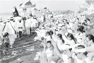  ?? — Gambar Reuters ?? DOA PENYUCIAN: Ratusan penganut Hindu berdoa di sepanjang pantai semasa upacara Melasti menjelang hari suci ‘Nyepi’ di Gianyar, Bali, Indonesia kelmarin.