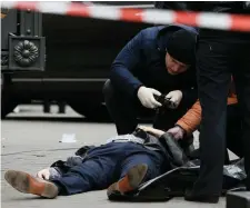  ??  ?? Investigat­ors inspect the body of Denis Voronenkov, who was shot dead in Kiev yesterday. Photo: Reuters