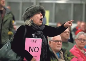  ?? RICK WOOD/MILWAUKEE JOURNAL SENTINEL ?? A woman who declined to give her name protests a proposal to require parking fees in Milwaukee County parks. About 300 county residents showed up at the Mitchell Park Domes to voice disapprova­l of the plan to collect the fees at parks, parkways and the...
