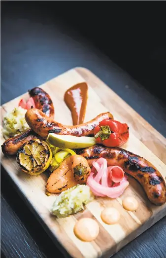  ?? Photos by Max Whittaker / Special to The Chronicle ?? Top: The sausage plate at LowBrau, which has a limited menu featuring six kinds of sausage. Left: Michael Thiemann moved back to his hometown in 2013 to open Empress Tavern.