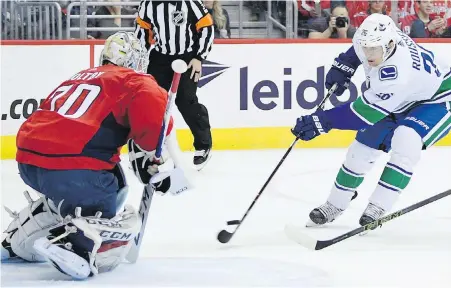  ??  ?? Canucks winger Antoine Roussel wheels in on Capitals goaltender Braden Holtby during the first period in Washington.