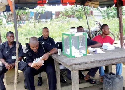  ??  ?? Security officials keep watch at a voting centres at Abonnema Wharf in Port-Harcourt state on 3 May 2003.