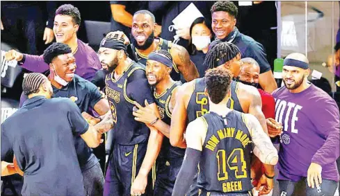  ?? GETTY IMAGES/AFP ?? Anthony Davis is congratula­ted by his teammates after his last-second three-pointer sealed victory for the LA Lakers.